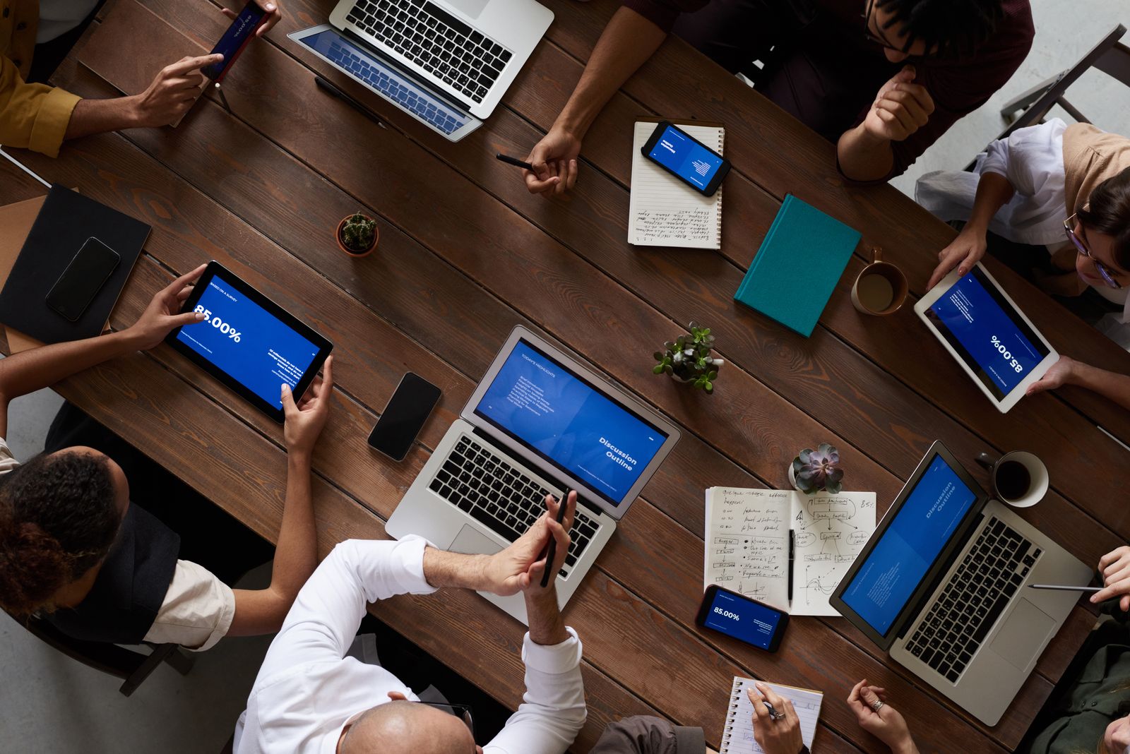 The SMCPL offshore BPO company team collaborating around a table with laptops in a modern office
